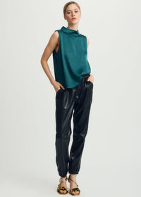 Woman wearing Melissa Nepton's deep sea sleeveless top and black pants on a white background