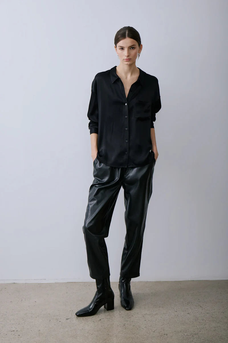 Person wearing Melissa Nepton's black Lizzie top and leather pants against a plain background