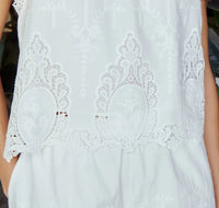 Close-up of a white Rio top by Melissa Nepton with intricate patterns.