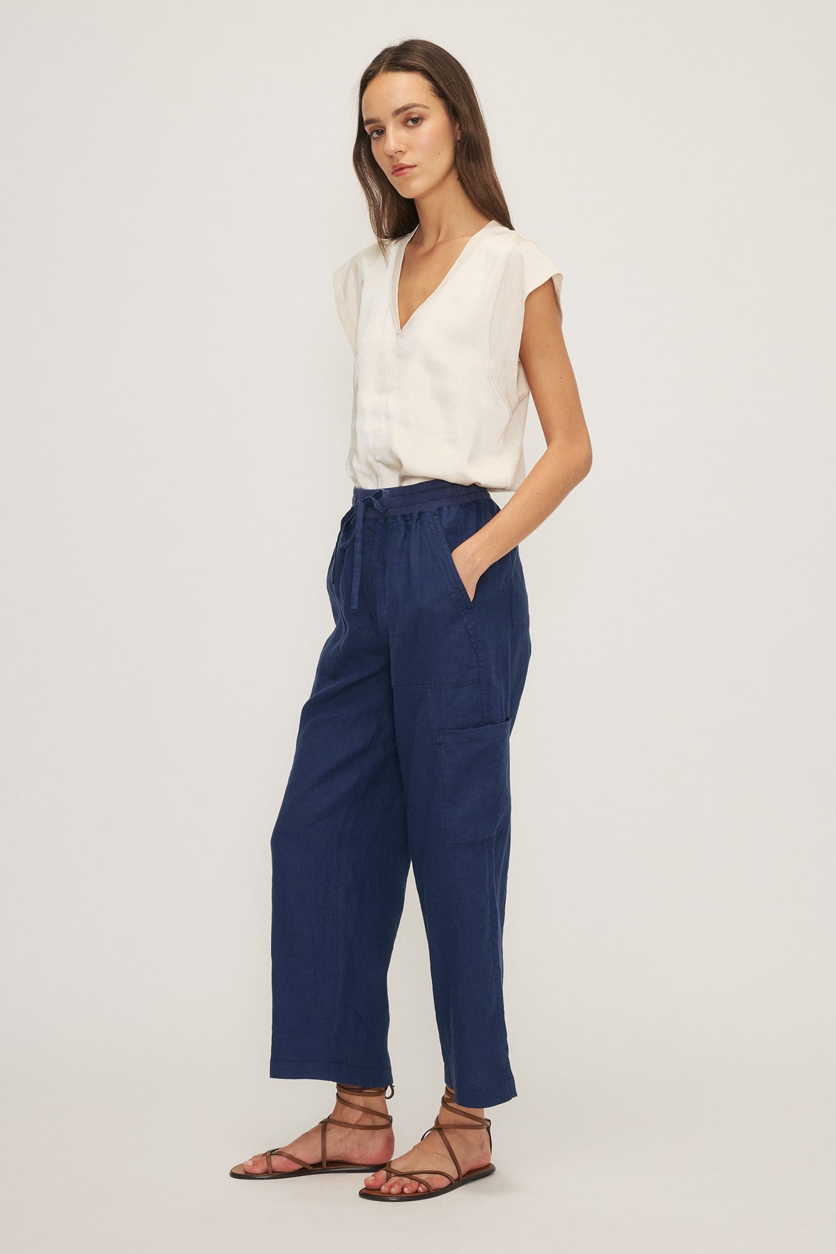 Side angle of Melissa Nepton James pants, paired with white blouse and strappy sandals – relaxed linen fit in Newmarket area