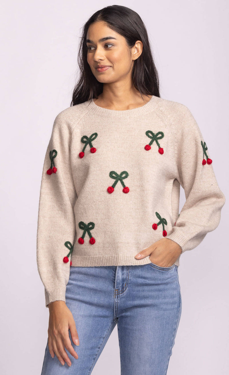 Pink Martini Mon Cherry Sweater in beige knit with red cherry embroidery, styled with denim – available at Lemonberry Aurora