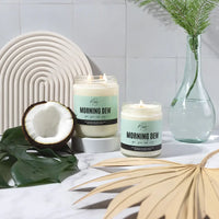 Morning Dew Candle by Market Candle Company displayed beside a coconut and palm leaves.