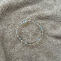 Namaste Jewellery Dania Stone Bracelet Aqua Pearl blue and clear beaded stretch bracelet flat lay on soft neutral fabric