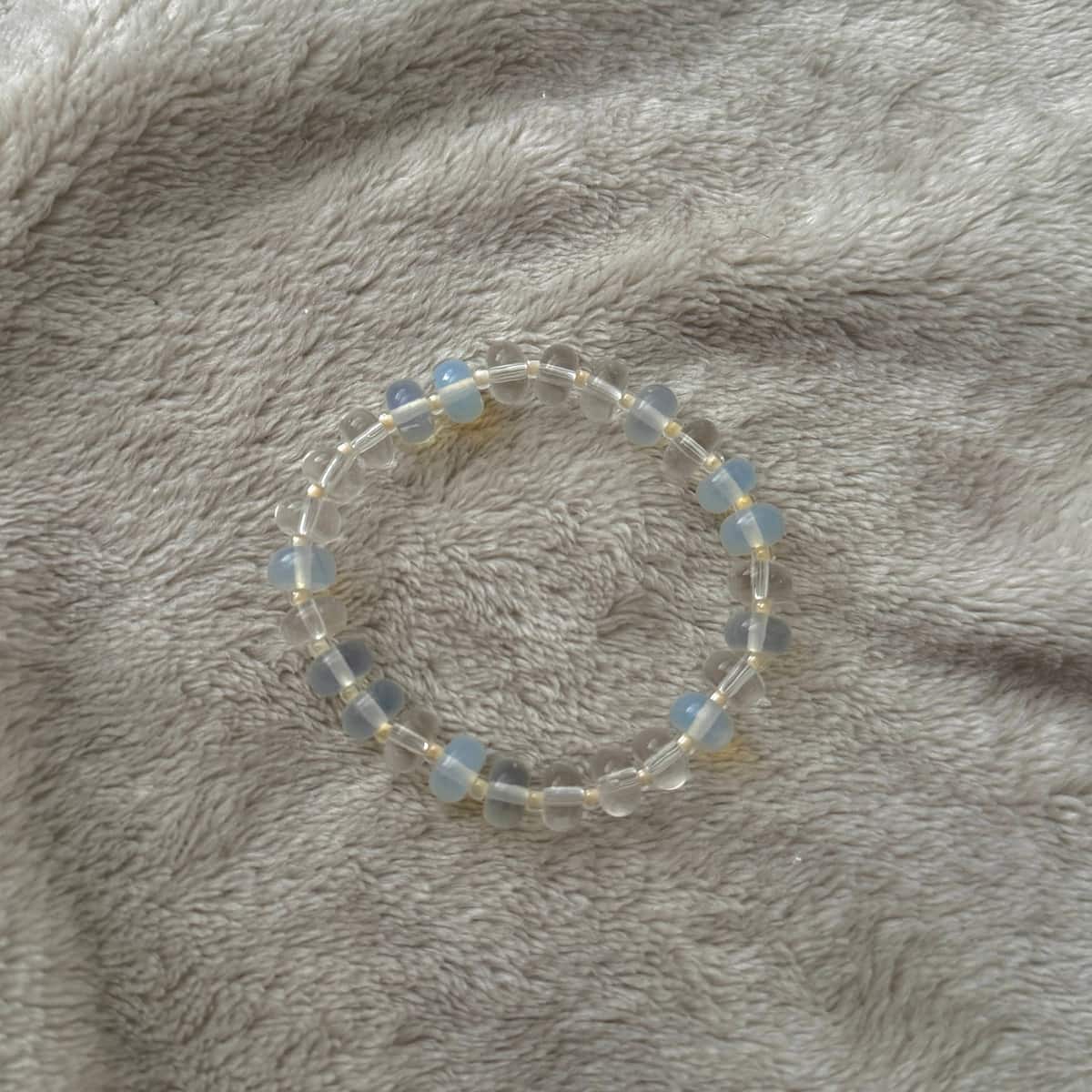 Namaste Jewellery Dania Stone Bracelet Aqua Pearl blue and clear beaded stretch bracelet flat lay on soft neutral fabric
