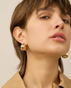 Model looking at the camera wearing Nouveaux Puff Earrings  by Jenny Bird Canada, available at Lemonberry in Aurora, Ontario