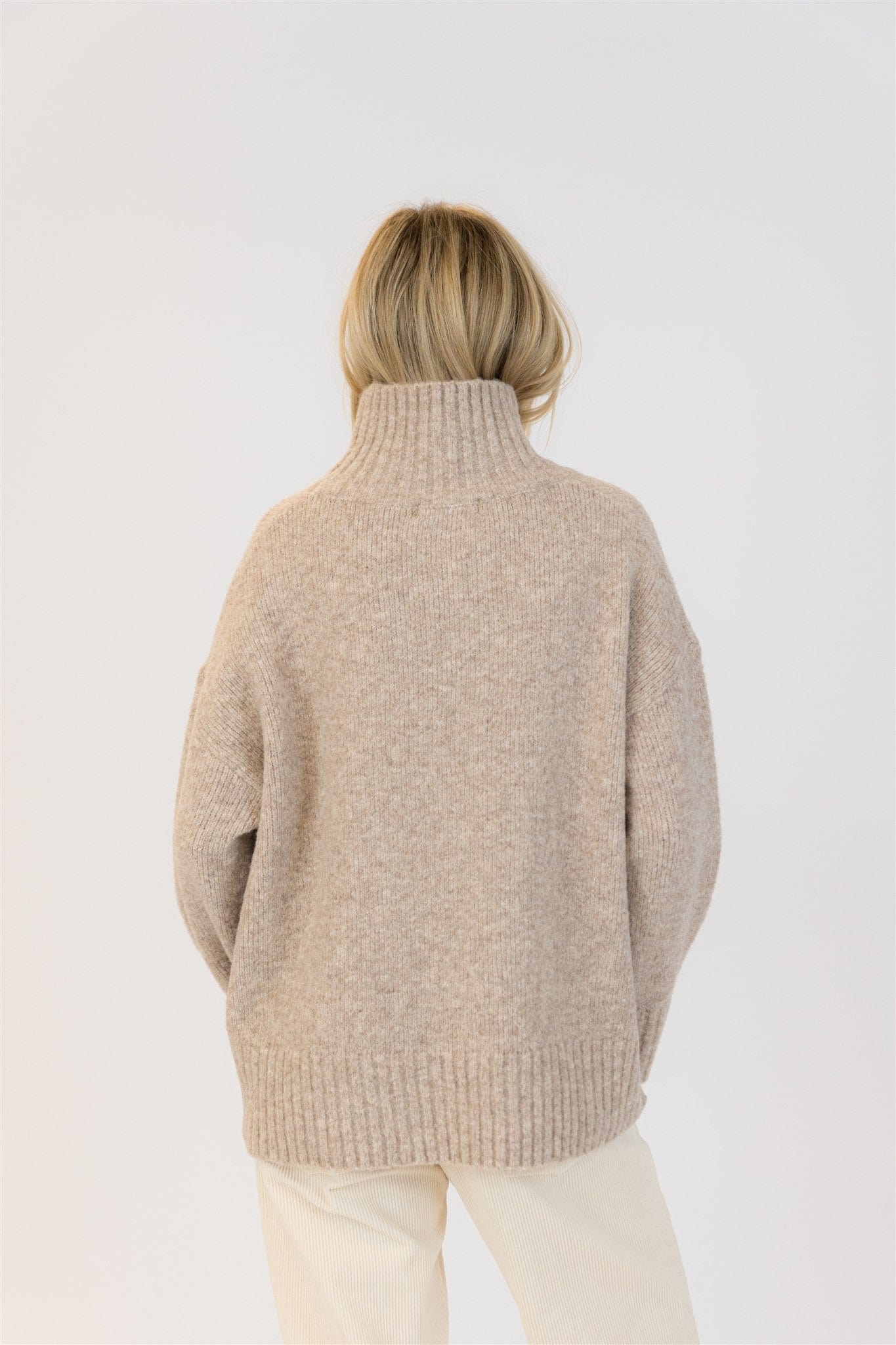 Back view of the Lyla & Luxe Oliver mockneck sweater showing relaxed fit and ribbed hem