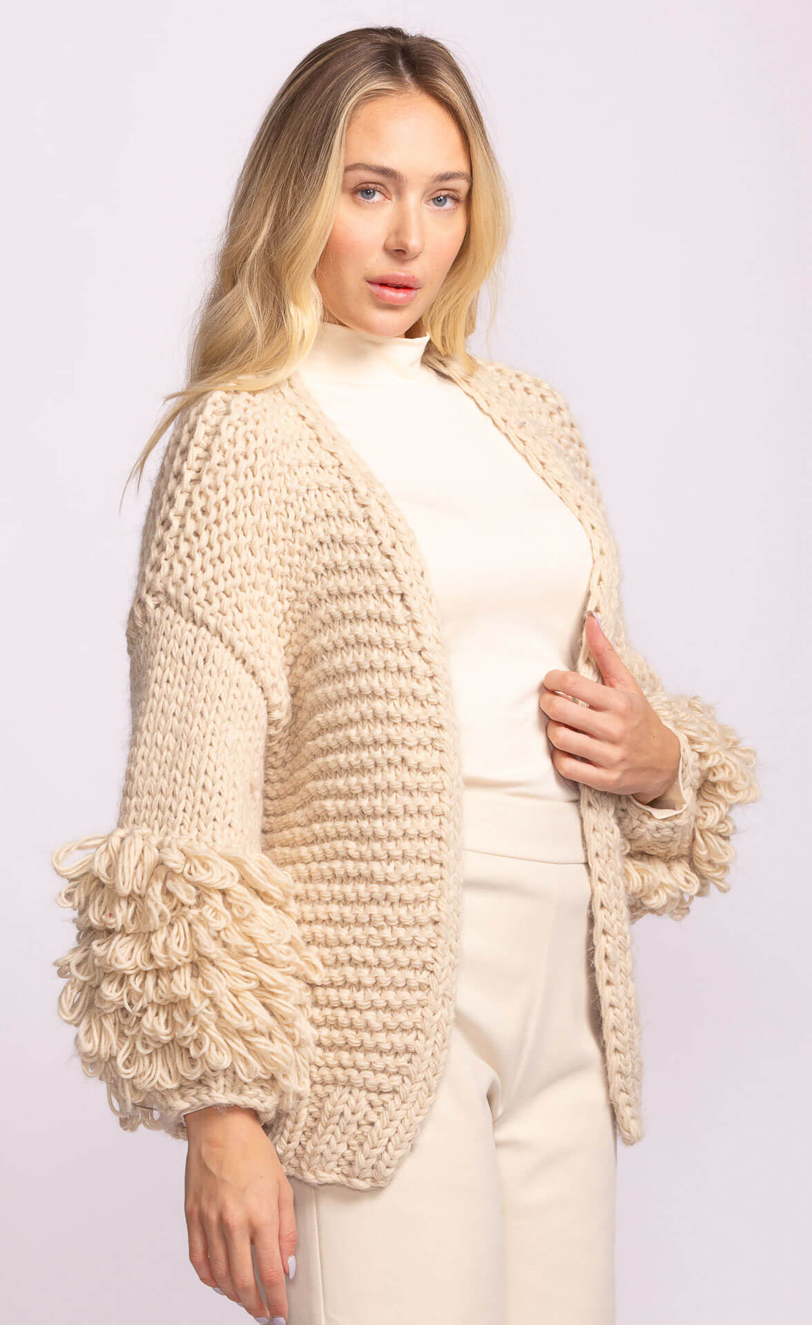 Close-up of Pink Martini Palermo Sweater in cream, highlighting voluminous looped sleeves and cozy knit – available at Lemonberry