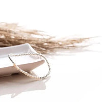 Pearl and silver intention bracelet in bright natural light on ceramic dish — Lemonberry in Aurora