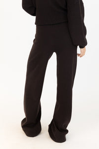 Back of chocolate brown Lyla & Luxe pants with clean waistband and fluid silhouette