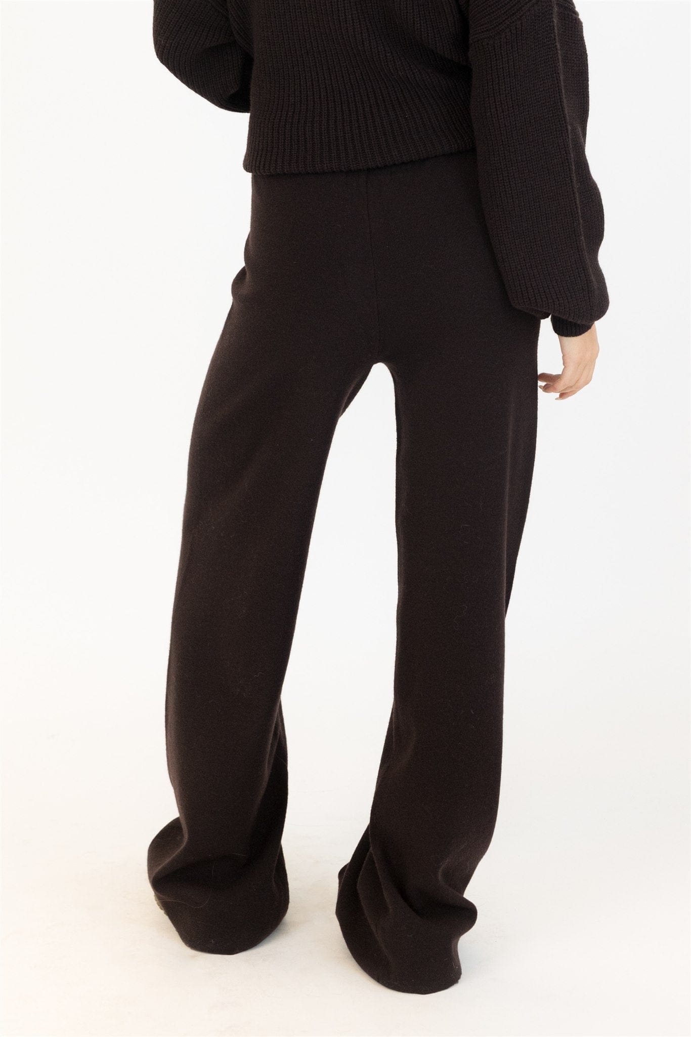 Back of chocolate brown Lyla & Luxe pants with clean waistband and fluid silhouette