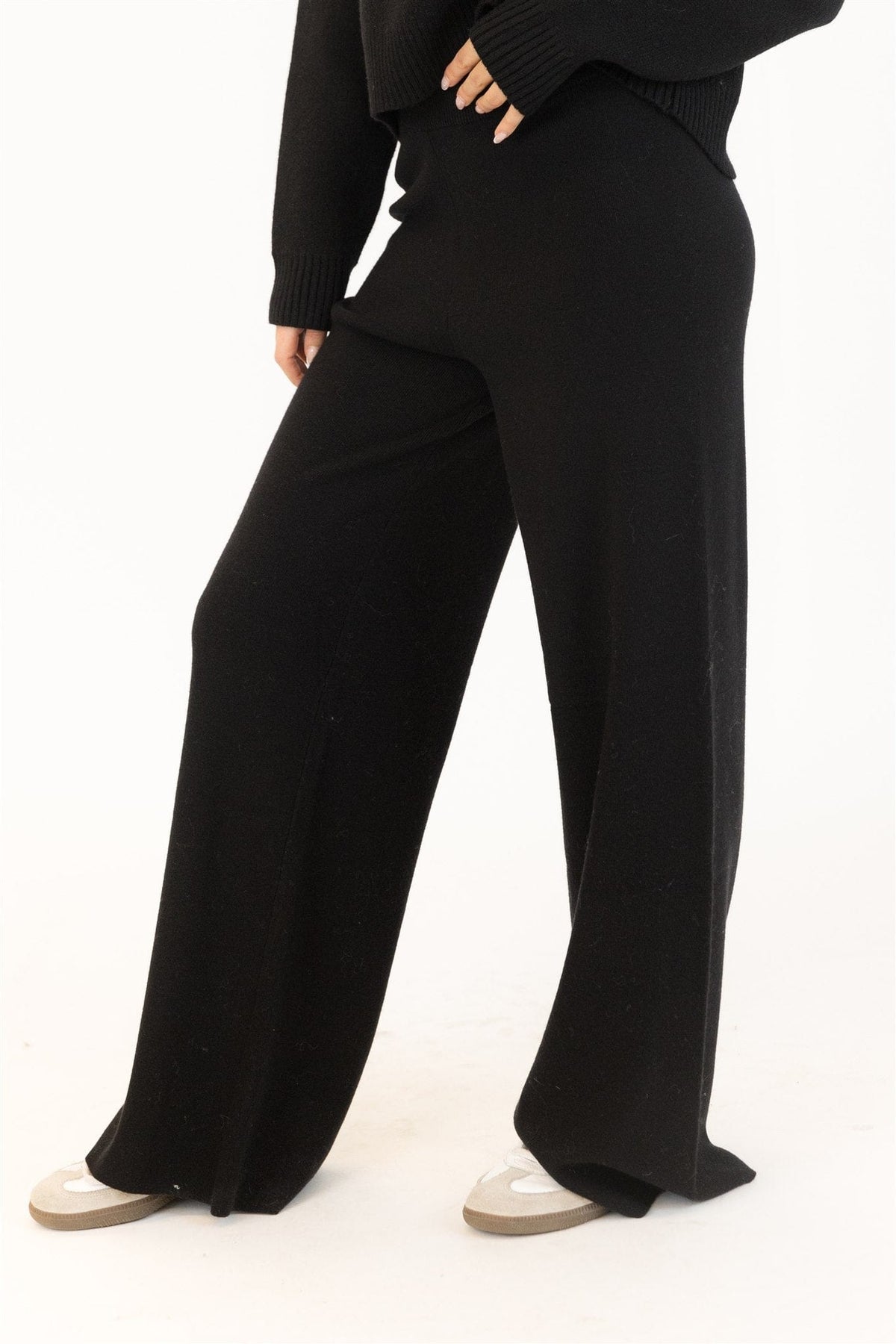Side view of wide-leg brown pants showing drape and relaxed fit