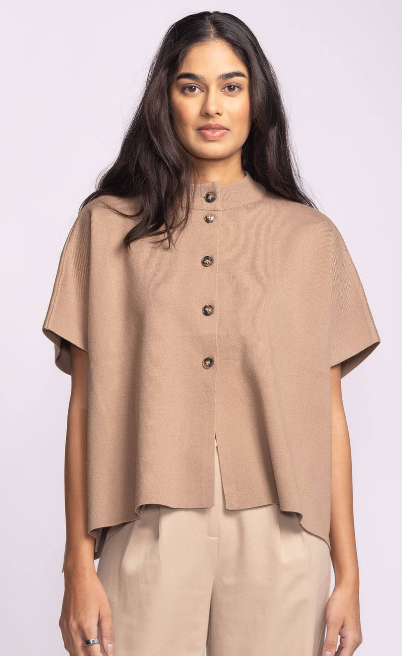 Front view of Pink Martini Melrose Sweater in tan, featuring stand collar and short sleeves, styled with beige trousers.