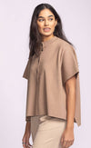 Model wearing the Pink Martini Melrose Sweater in tan, short sleeve knit with button-up front, side profile view.
