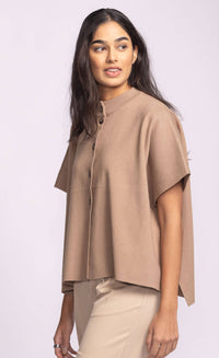 Model wearing the Pink Martini Melrose Sweater in tan, short sleeve knit with button-up front, side profile view.