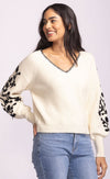 Pink Martini Pavia Sweater in cream, featuring black floral embroidery on balloon sleeves and whipstitch neckline detail, styled with denim.