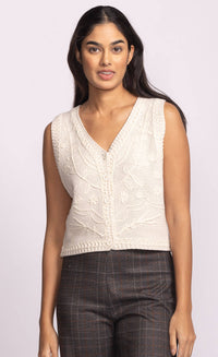Model wearing the Pink Martini Sevilla ivory knit vest with floral cable design, front button closure.