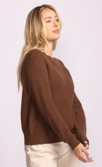 Woman wearing a brown sweater against a white background