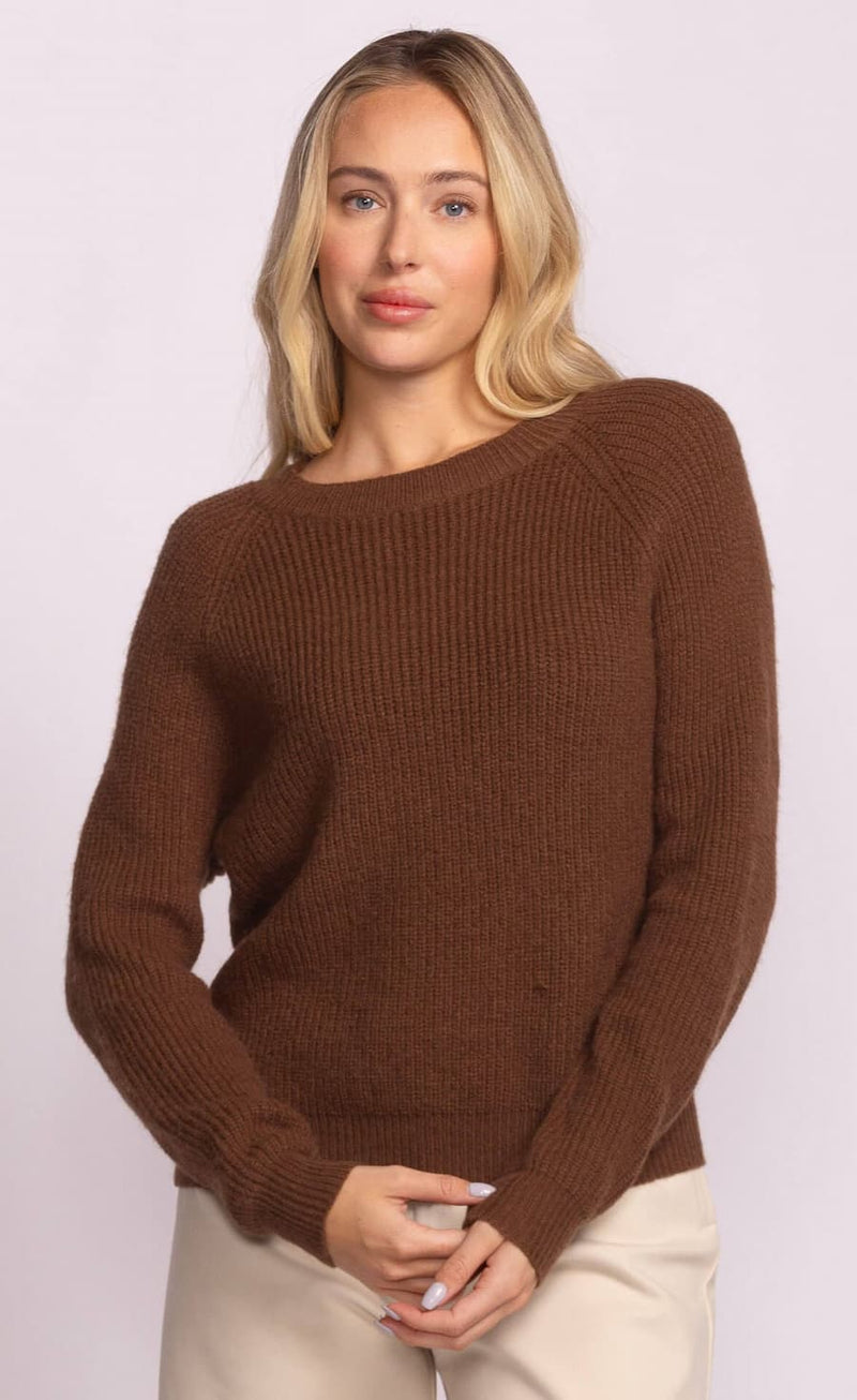 Woman wearing a brown sweater against a light background
