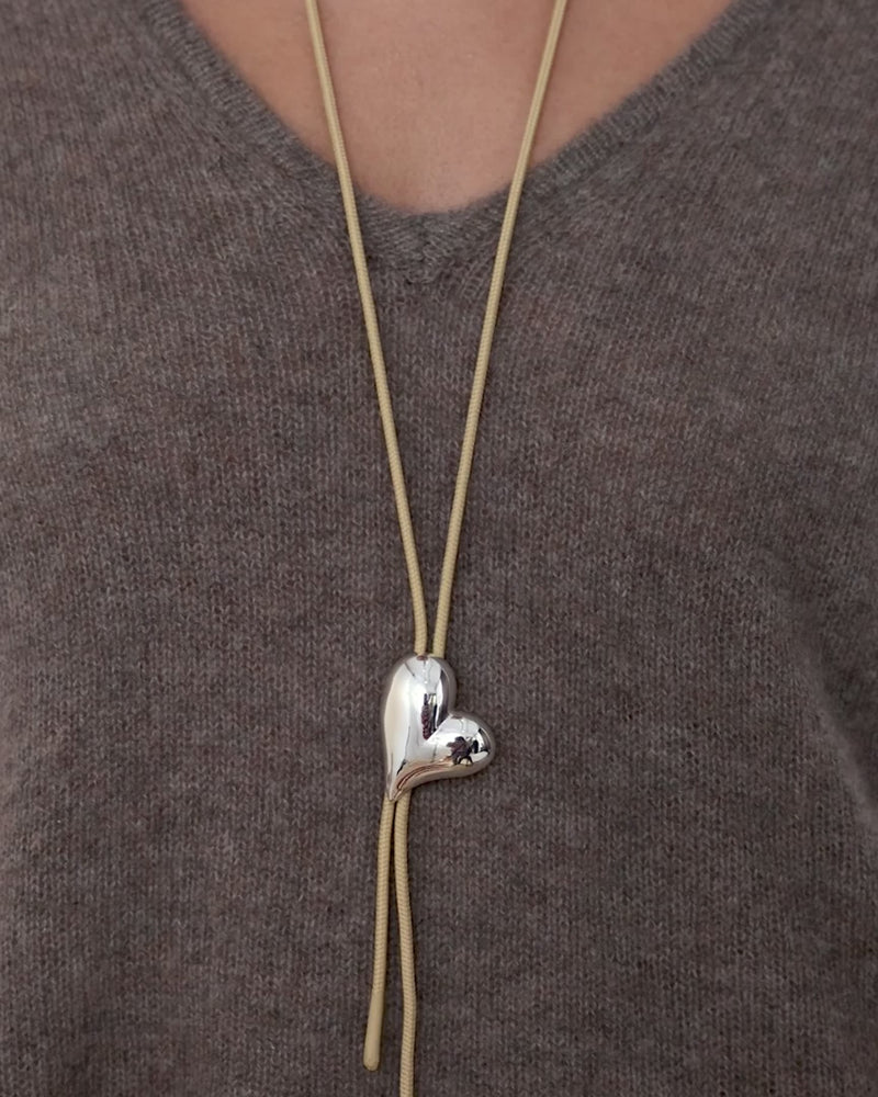 video showing a model tighten the bow tie on the Jenny Bird necklace