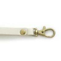 Close-up of clasp and wristlet strap on Quinn Card Wallet in white vegan leather