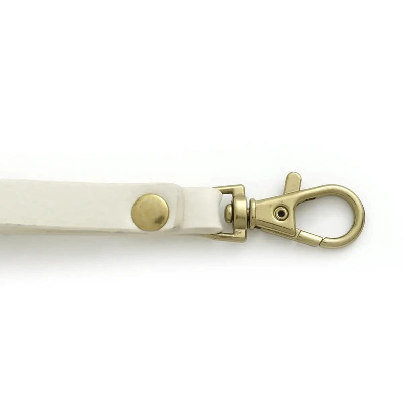 Close-up of clasp and wristlet strap on Quinn Card Wallet in white vegan leather