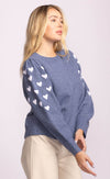 side view of Revello blue sweater with playful embroidered hearts down the sleeve