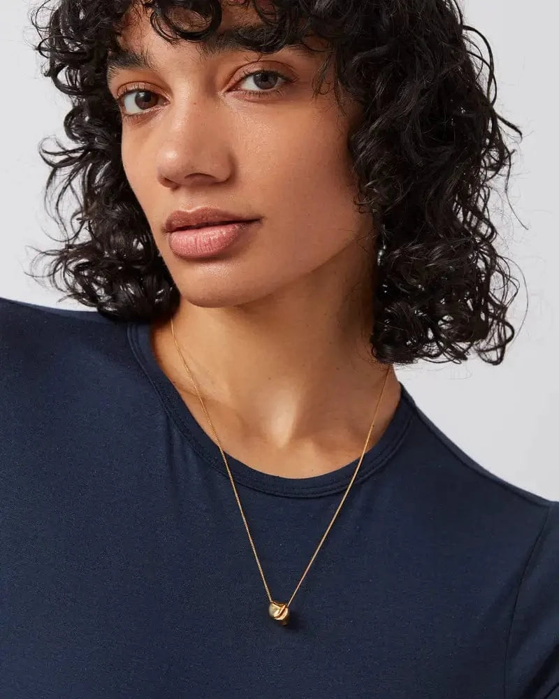 Model wearing the Rio Pendant Necklace by Jenny Bird, styled for Lemonberry near Richmond Hill — delicate gold chain with folded charm detail