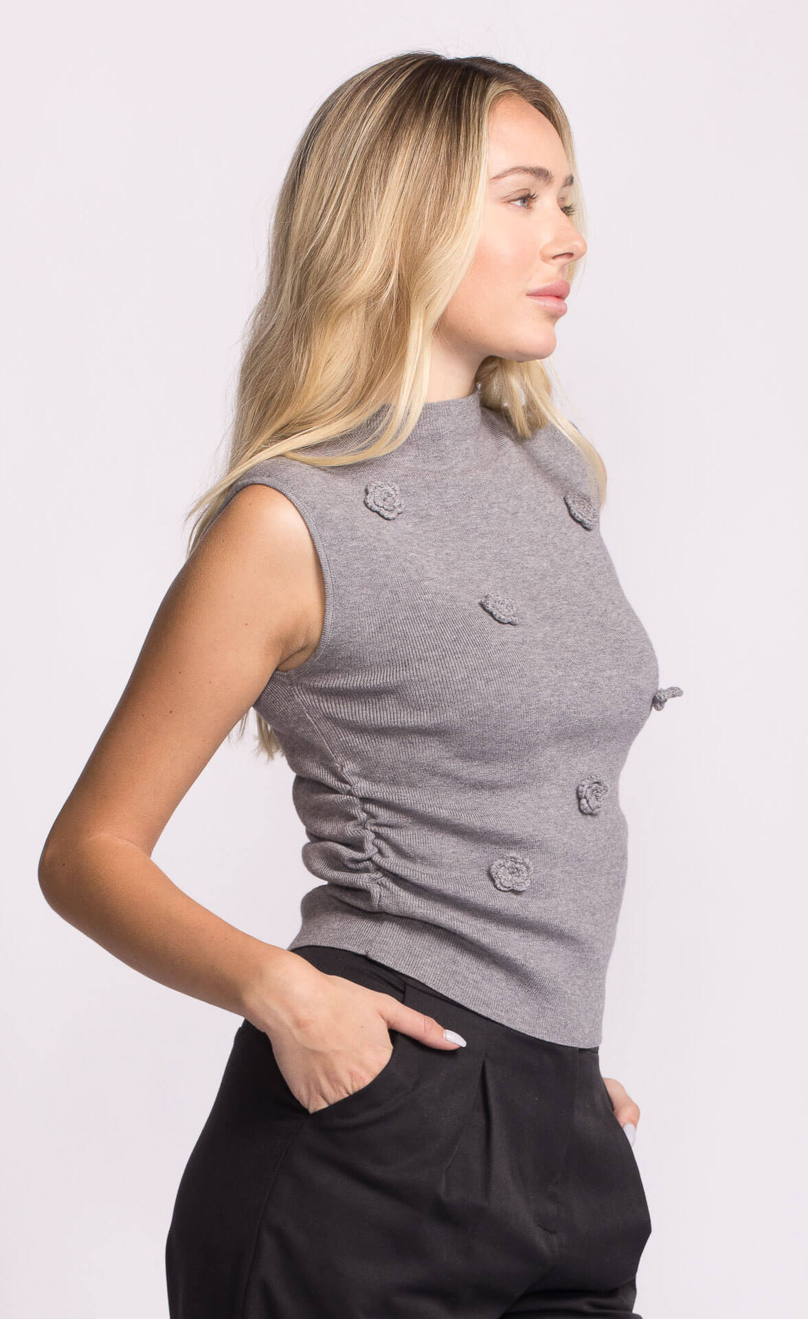 Side view of grey Rosslie sleeveless knit top with raised floral details and fitted silhouette.