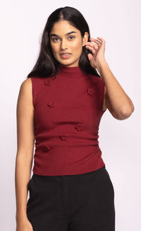 Close-up front of red Rosslie mockneck sleeveless sweater with textured floral knit design.