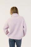 Back view of SAHAR sweater in lilac, ribbed texture and mockneck detail shown, styled with mid-rise denim