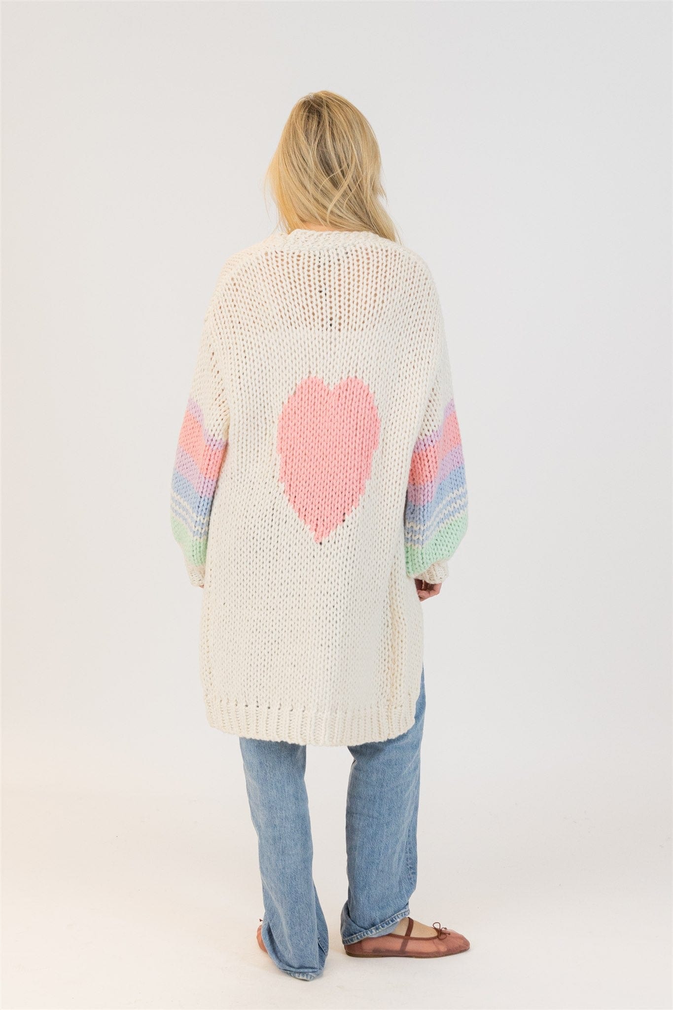 Full back view of model in Lyla + Luxe Shiloh cardigan showing large pink heart and pastel sleeves – clean studio background

