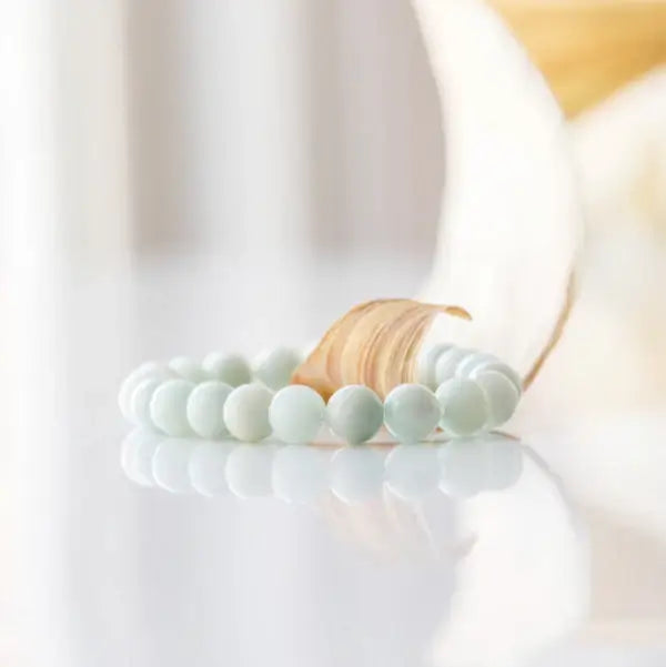 Amazonite gemstone bracelet on white floral backdrop