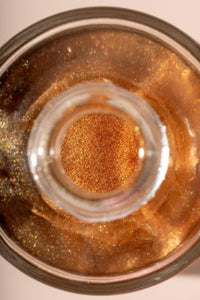 Top view of St. Barts dry shimmering oil bottle showing bronze glow inside.