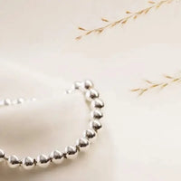 Close-up of sterling silver bracelet with natural light and soft shadow — handmade in Canada