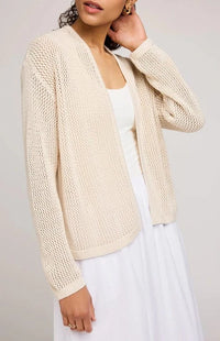Close-up of model wearing Gentle Fawn Toledo open knit cardigan over white dress, highlighting the open knit pattern and cozy texture, at Lemonberry just north of Richmond Hill, ON