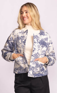 Woman smiling in the Toulon Jacket by Pink Martini, hands in pockets, showcasing whimsical blue animal print