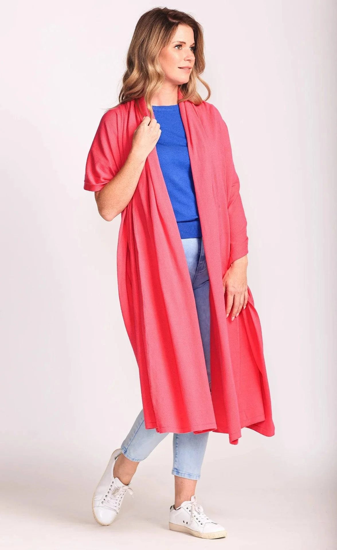 Model draping the Traveler's Blanket Scarf by Pink Martini open over her shoulders like a shawl.