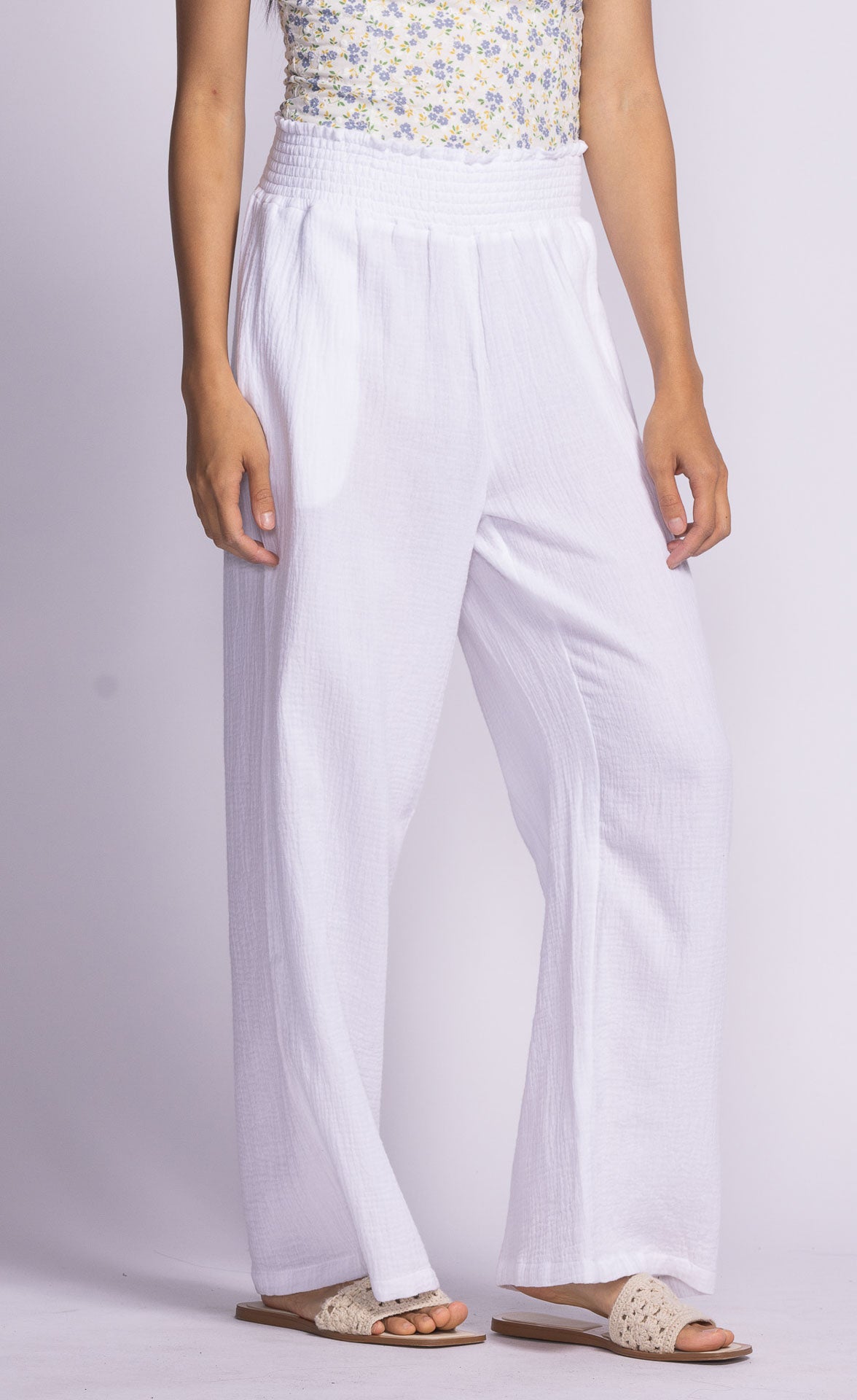 Close-up of white Vail Pants by Pink Martini, model with a slight bend in the knee, highlighting the fabric texture and pocket detail.
