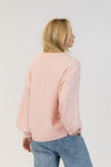 Back view of pink Lyla + Luxe Yassie sweater showing soft texture and relaxed fit