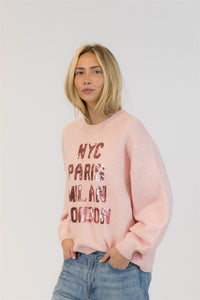 Side view of model in pink Yassie crewneck pullover by Lyla + Luxe, hands in pockets