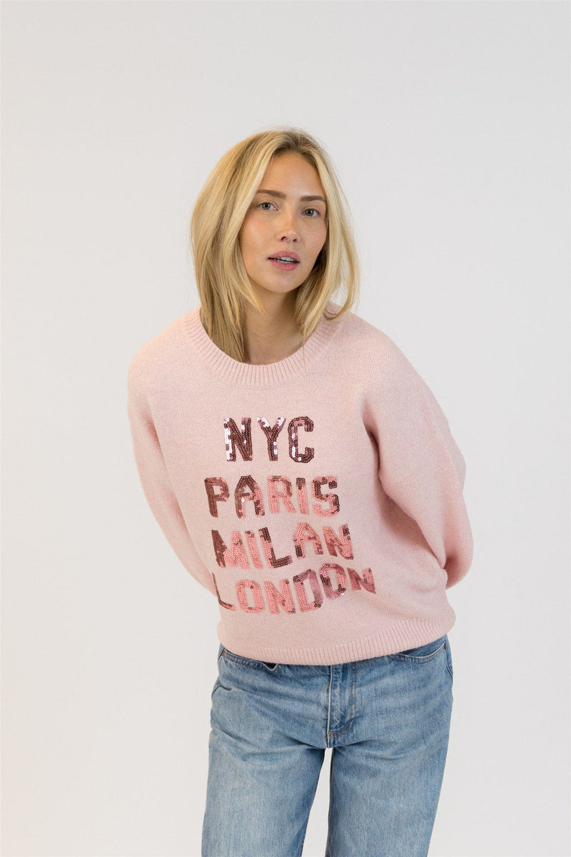 Model tilting forward in Lyla + Luxe Yassie sequin pullover with balloon sleeves and NYC, Paris, Milan, London sequins