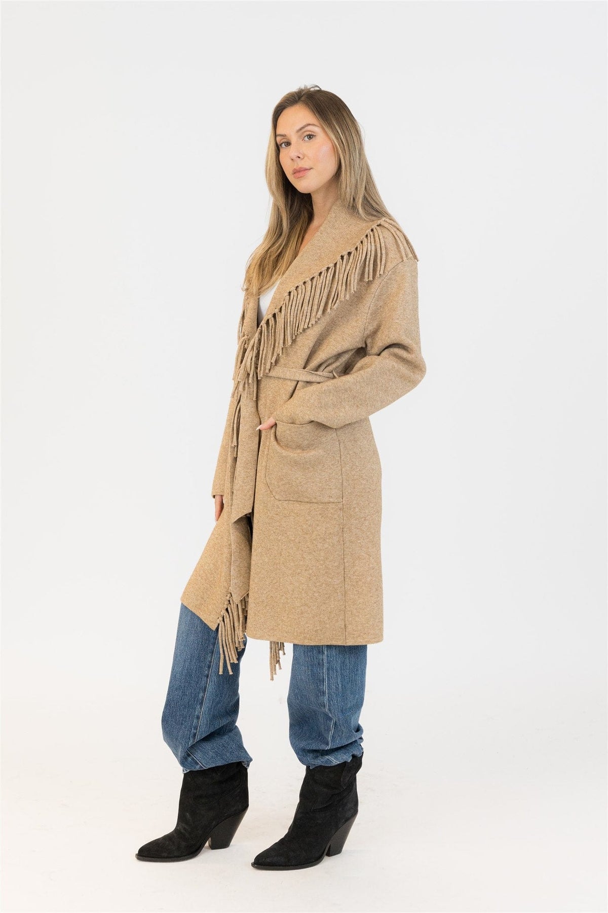 Side profile of model in camel Ziggy fringe wrap coat, showing fringe shoulder detail