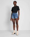 A full view of the mid roll shorts by 7 For All Mankind paired with a black t-shirt and white ankle boots.